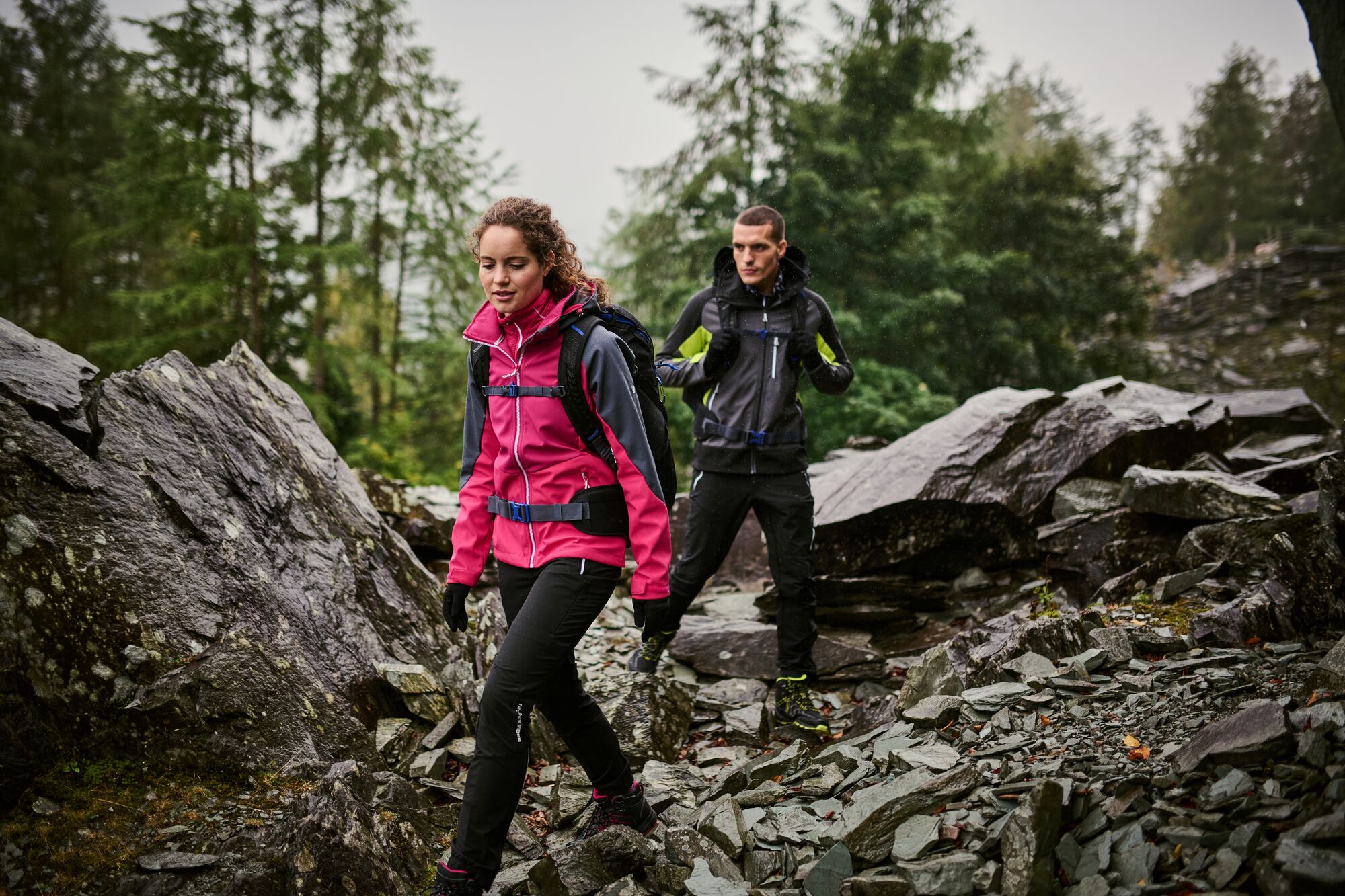 A man and a woman backpacking through a rocky trail